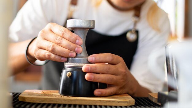 사진 baristas는 컵 냄비에 뜨거운 커피 원두를 준비하여 음료 소규모 비즈니스를 위한 카페 숍의 증기 커피숍 개념을 위한 커피를 만듭니다.