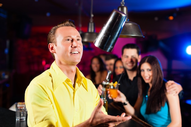 Barkeeper in a pub is mixing cocktails or drinks