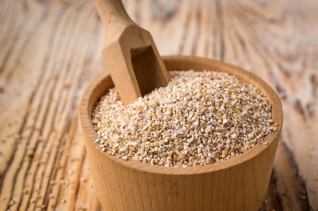 Barley groats in bowl on a wooden background Healthy dietary cereals concept