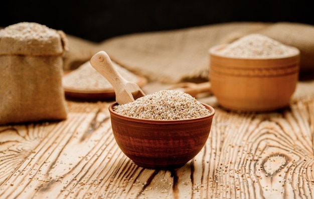 Barley groats in bowls and bags on a wooden background High quality photo