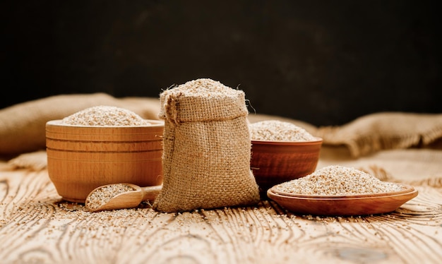 Barley groats in bowls and bags on a wooden background High quality photo