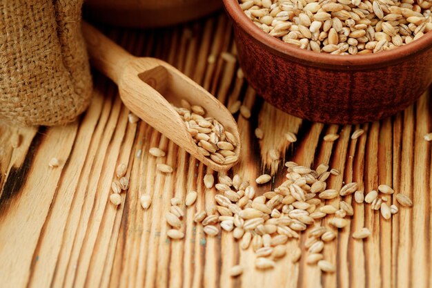 Barley groats in bowls and bags on a wooden background High quality photo