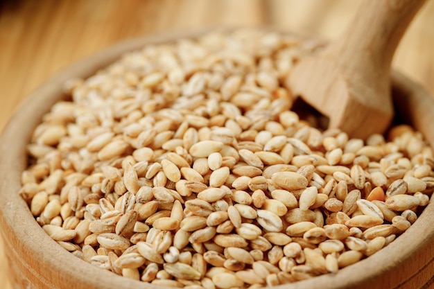 Barley groats in bowls and bags on a wooden background High quality photo