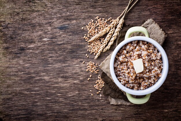 Barley porridge with butter in green pot 