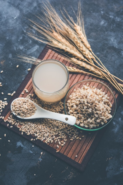 生および調理済みのパール大麦小麦または種子を含むガラス中の大麦水。セレクティブフォーカス