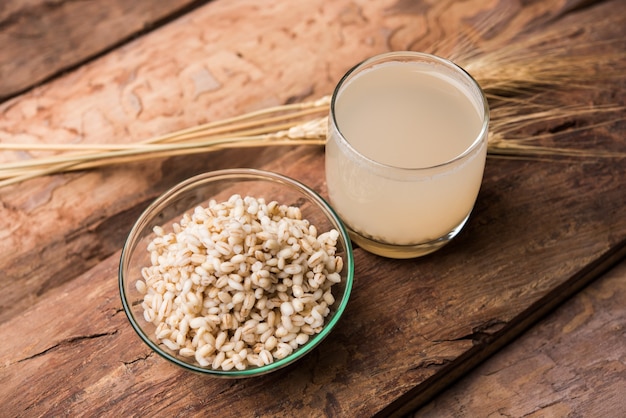 Barley water in glass with raw and cooked pearl barley wheat or seeds. selective focus