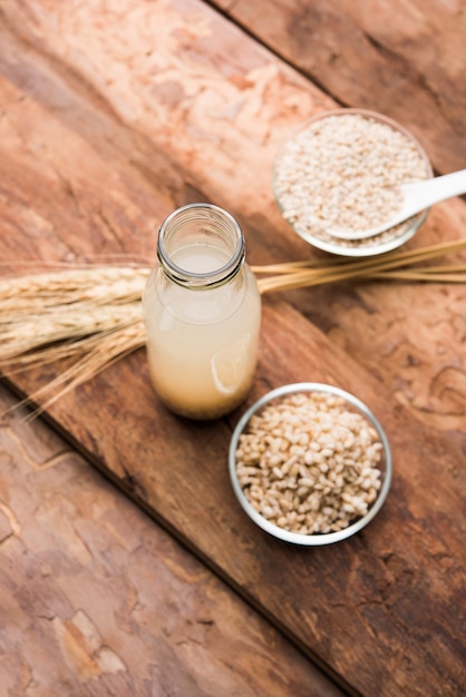 Barley water in glass with raw and cooked pearl barley wheat or seeds. selective focus