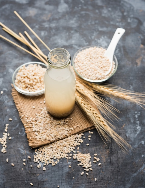 Barley water in glass with raw and cooked pearl barley wheat or seeds. selective focus