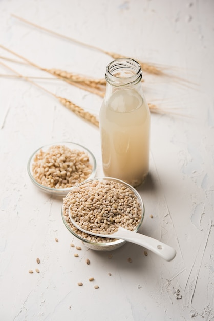 Barley water in glass with raw and cooked pearl barley wheat or seeds. selective focus