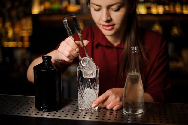 Barmaid prepares an alcoholic cocktail Caipirinha