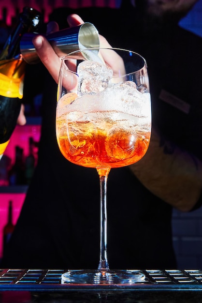 Barman bereidt Aperol Spritz-cocktail op toog