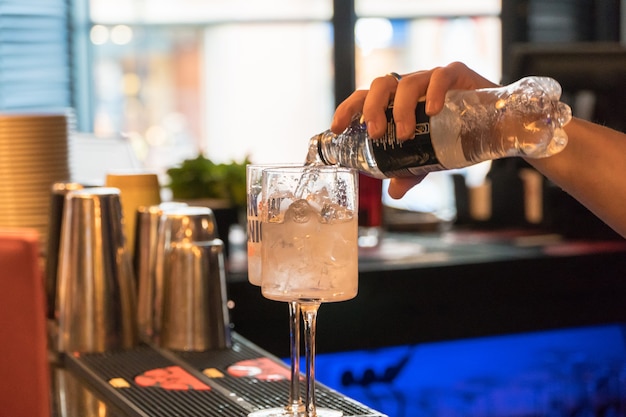 Barman bereidt een cocktail met ijs voor, close-up