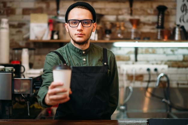 Photo barman in black apron stretches plastic cup