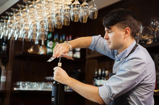 Barman concentreerde zich op het ontkurken van een elitedrankje aan de toog