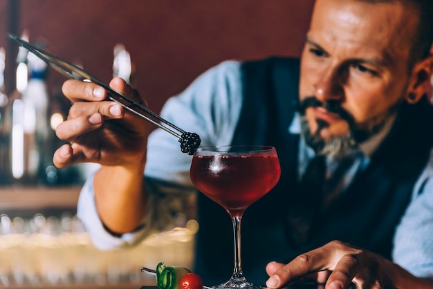 Foto barman die een cocktail bereidt in de bar.