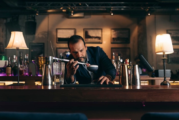Foto barman die een cocktail bereidt in de bar.