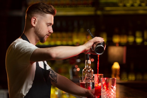 Foto barman die een cocktail maakt met een shaker