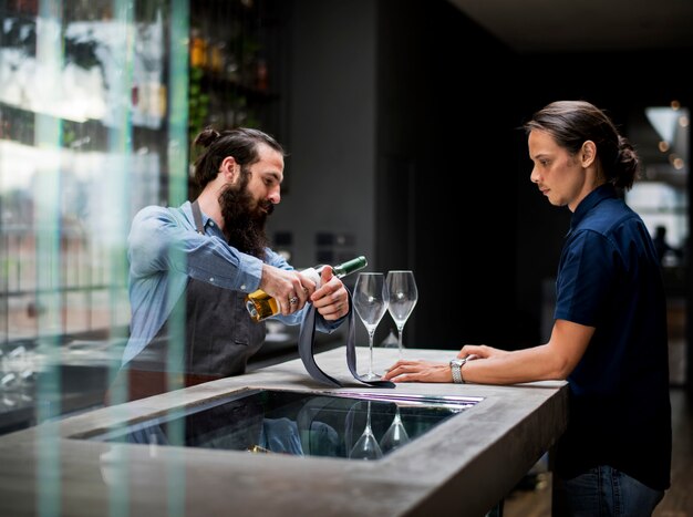 Barman die een wijn giet aan het glas