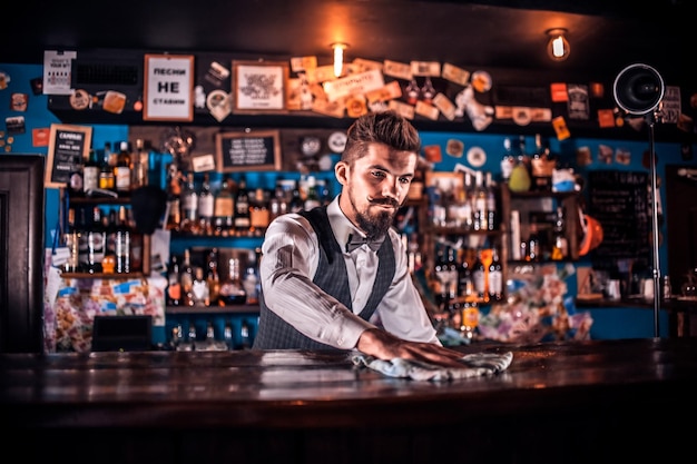 Photo barman formulates a cocktail at the saloon