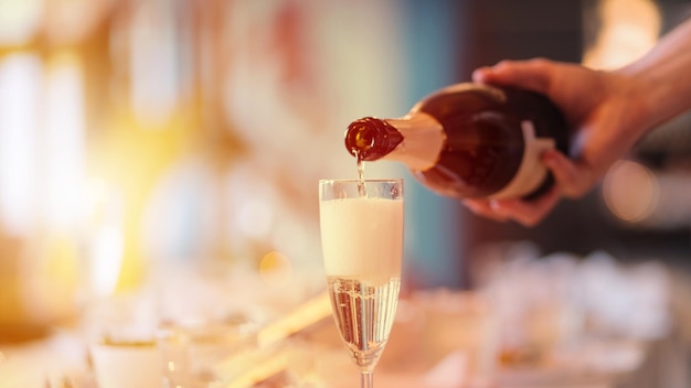 Barman giet champagne in een glas, close-up