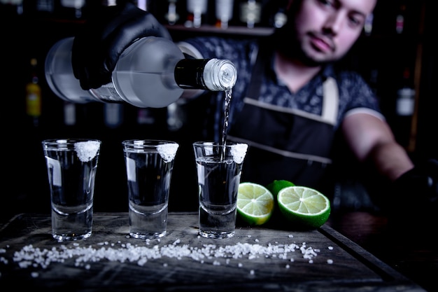 Barman giet tequila in de kleine glazen in de bar