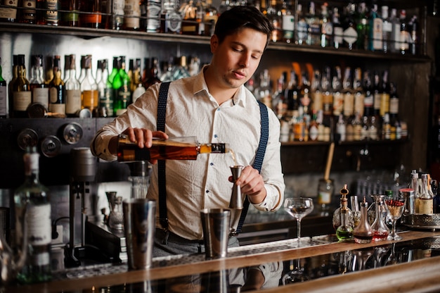 Barman in wit shirt maakt een alcohol cocktail