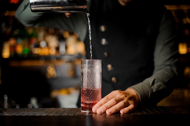 Barman maakt cocktail aan een toog