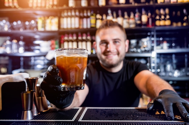 Barman maakt cocktail aan toog. Verse cocktails. Barman aan het werk. Restaurant. Nachtleven.