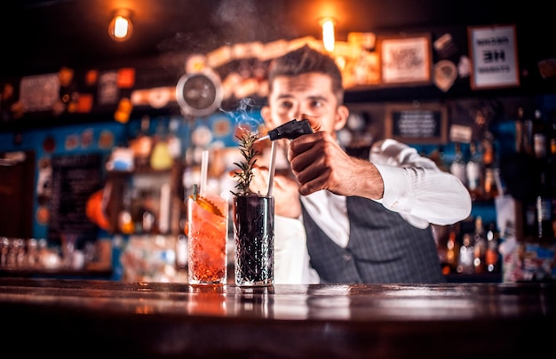 Barman maakt een cocktail achter de bar