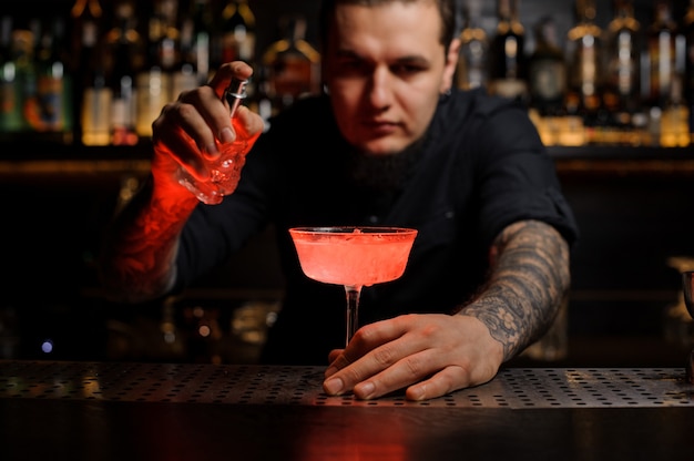 Foto barman met de heerlijke cocktail en de speciale verdamper op de toog
