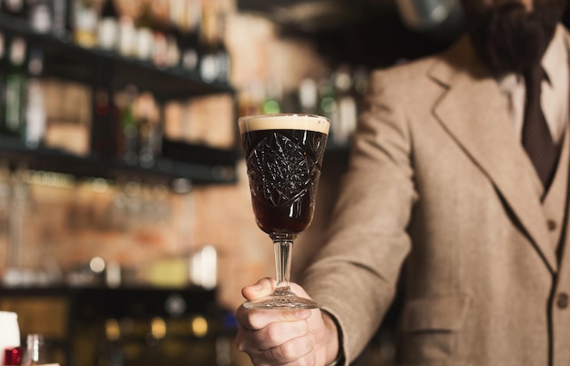 Barman met glas heerlijk vers donker ambachtelijk bier, degustatie bij brouwerij, kopieer ruimte