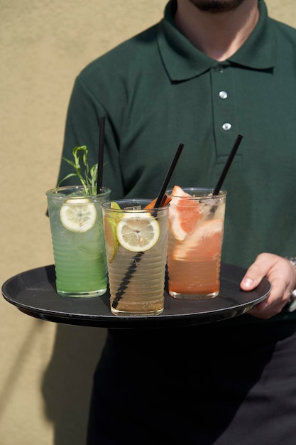 Barman met verschillende mojitoglazen