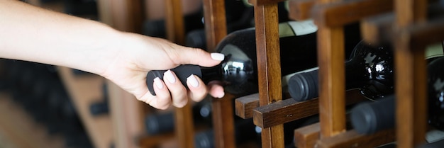 Barman neemt fles wijn van plank in kelder