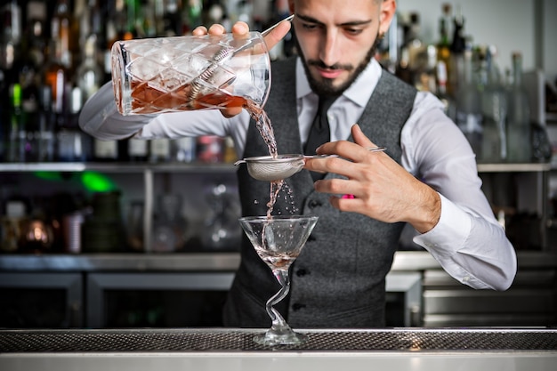 Photo barman pouring cocktail into glass