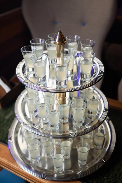 Barman pouring hard spirit into glasses in detail