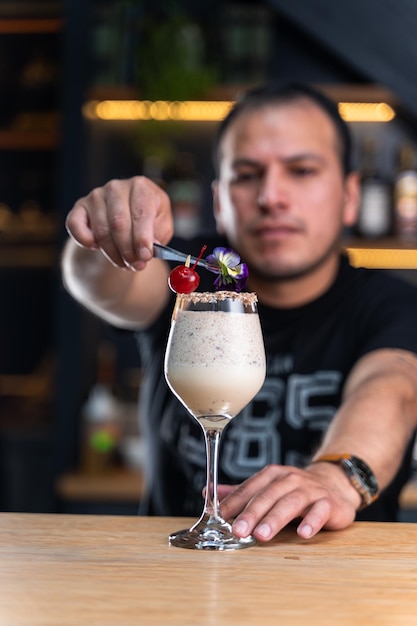 Barman preparing fruit cocktails at a bar counter By Yuri Ugarte Cespedes