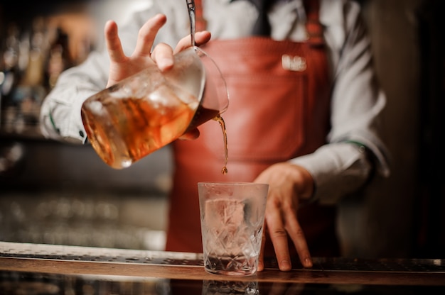 Le mani di barman nel bar interno rendendo l'alcool cocktail.