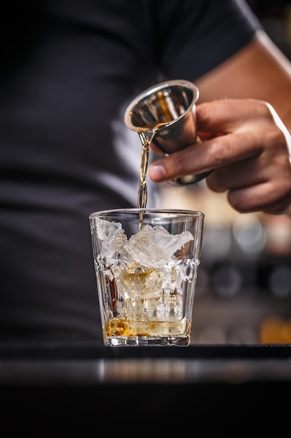 Barman schenkt alcohol uit een jigger