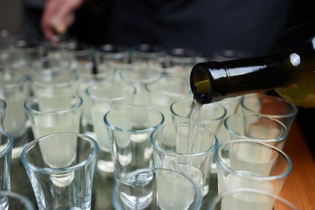 Barman schenkt in detail sterke drank in glazen