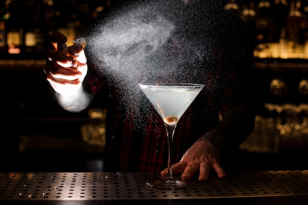 Barman sproeien bitter op het elegante glas met verse cocktail
