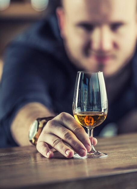 Foto barista con una tazza di whisky, cognac, brandy o rum