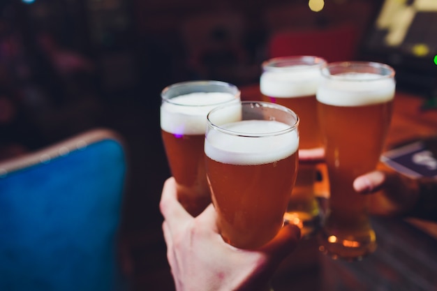 Barmanhanden die een lagerbier in een glas gieten.