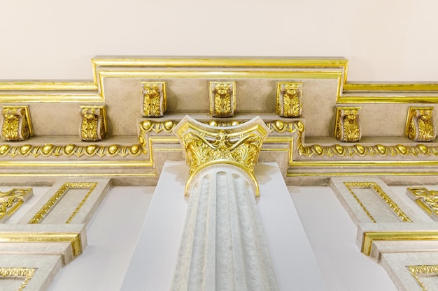 Baroque style column with capital decorative gold stucco on the ceiling fillet in luxurious expensive interior of large baroque royal living room