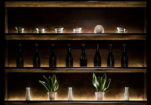 Foto barplank met flessen, potten, cactussen en interessant licht