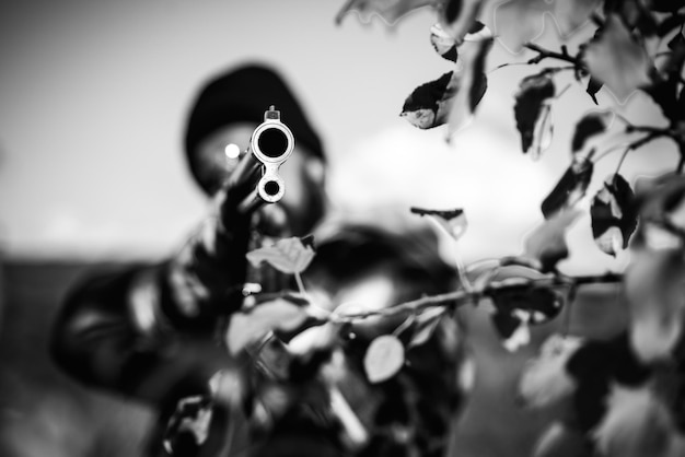 Barrel of a gun Hunter aiming rifle in forest Hunter with shotgun gun on hunt Poacher with Rifle Spotting Some Deers Hunting in spring forest