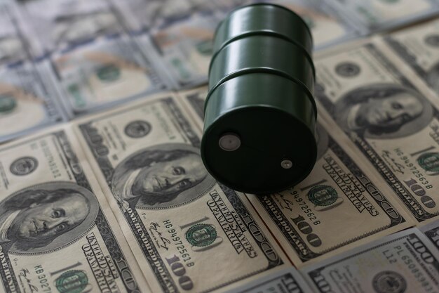 Фото Баррели нефти стоят на долларовых банкнотах. нефтяной бизнес, купля-продажа, добыча, обмен, торговый доход.