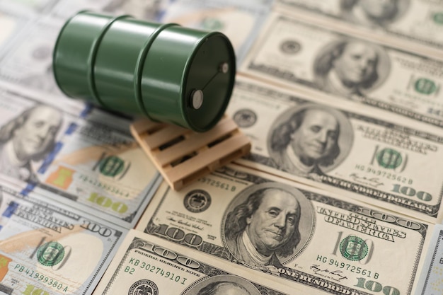 ドル紙幣の上に立っている石油のバレル。石油事業、買取販売、生産、為替、トレーディング収入。