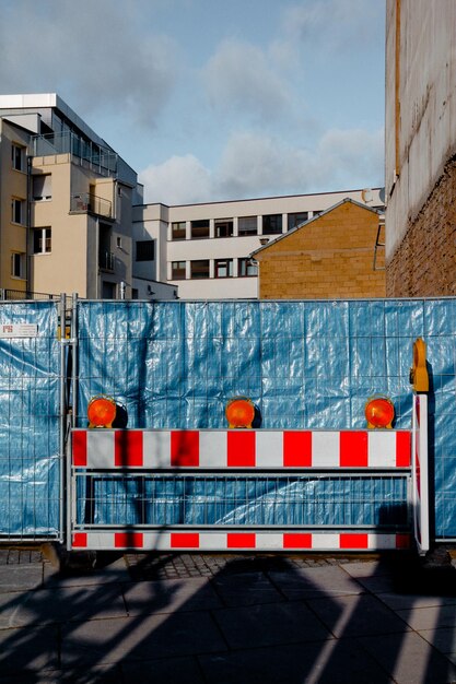 Photo barricade by fence against buildings at construction site in city