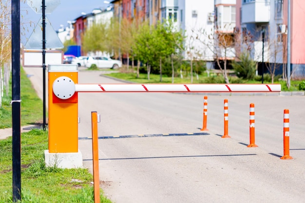 Barrier with a white and red stripe at the entrance of cars to a private area