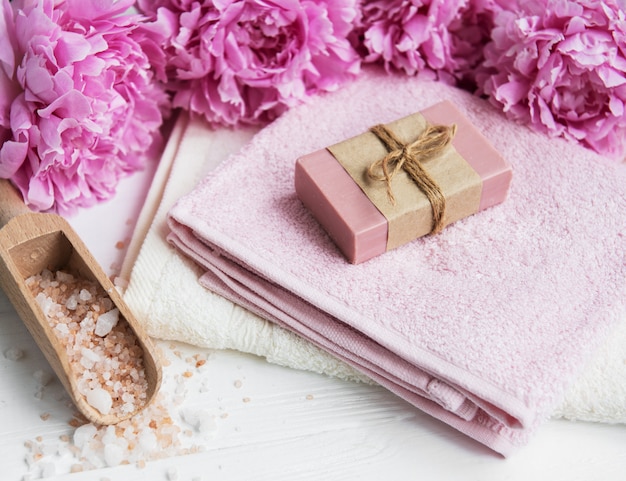 Bars of handmade soap,  soft towels and peony flowers